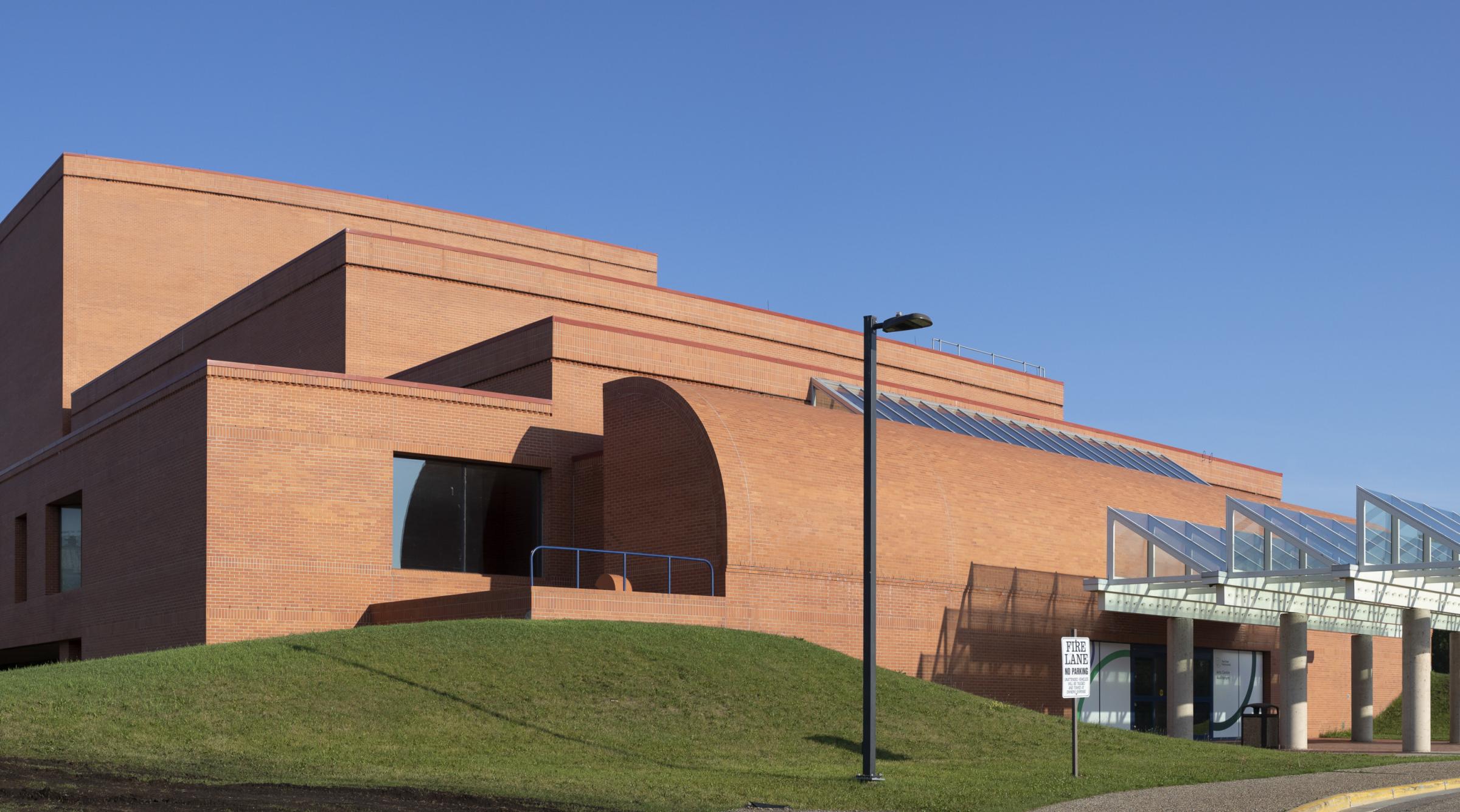 A panorama shot of the arts centre with rolling green hill in front.