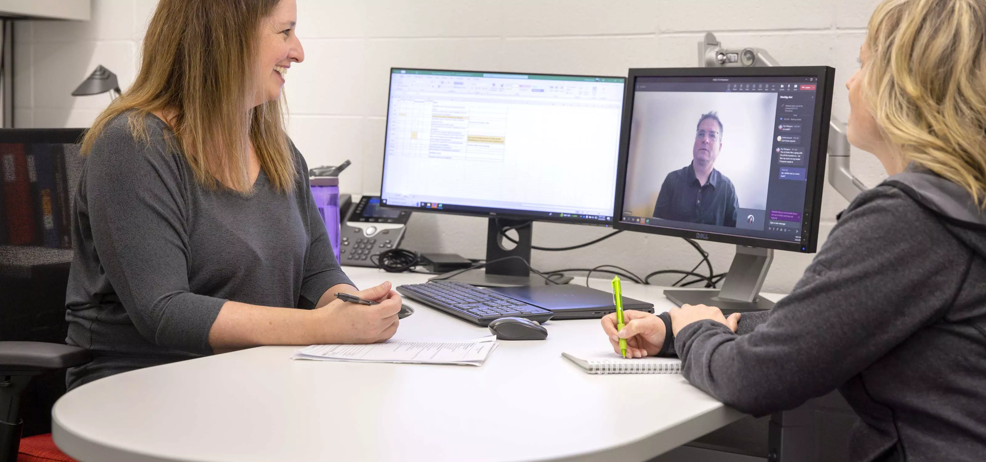 Two employees meeting with a client virtually.