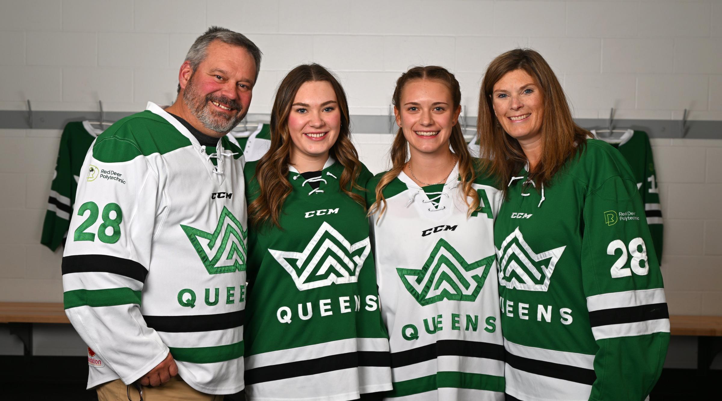 Smiling picture of a family of 4 wearing Queens hockey jerseys